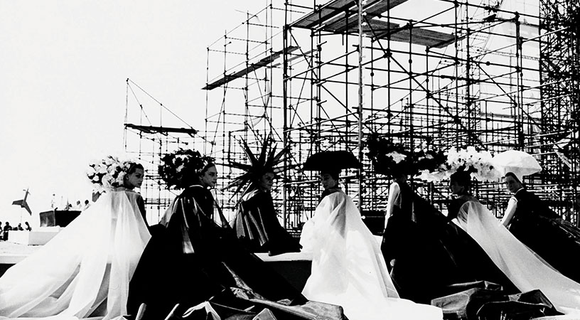 a group of women sit in front of a structure from the film 8 1/2