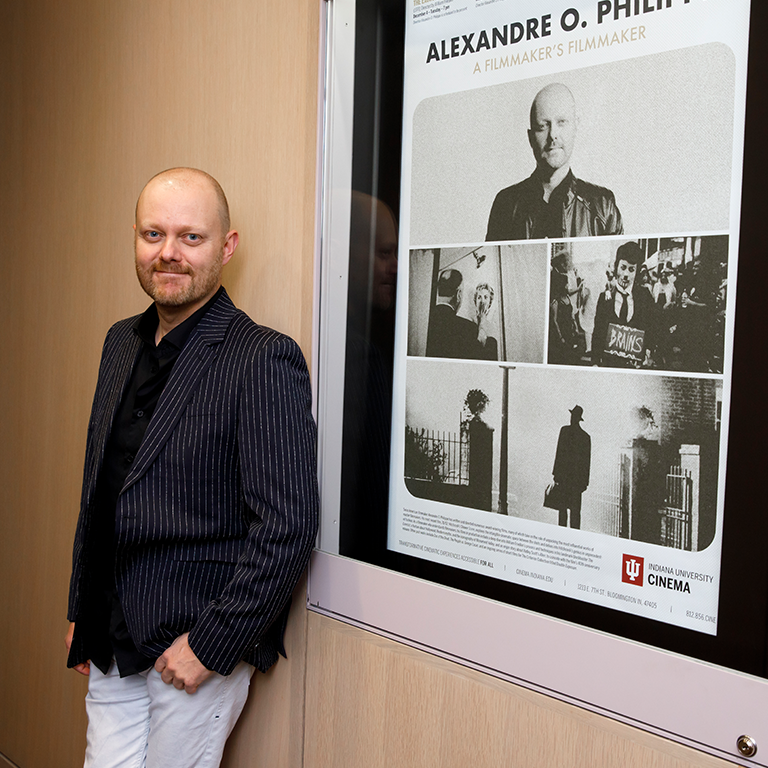 Alexandre O. Philippe stands by the poster for his film series at IU Cinema