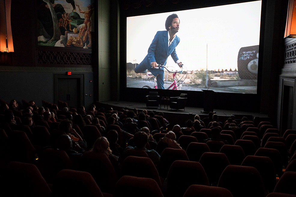 A clip of a music video by Boots Riley plays on screen at IU Cinema.