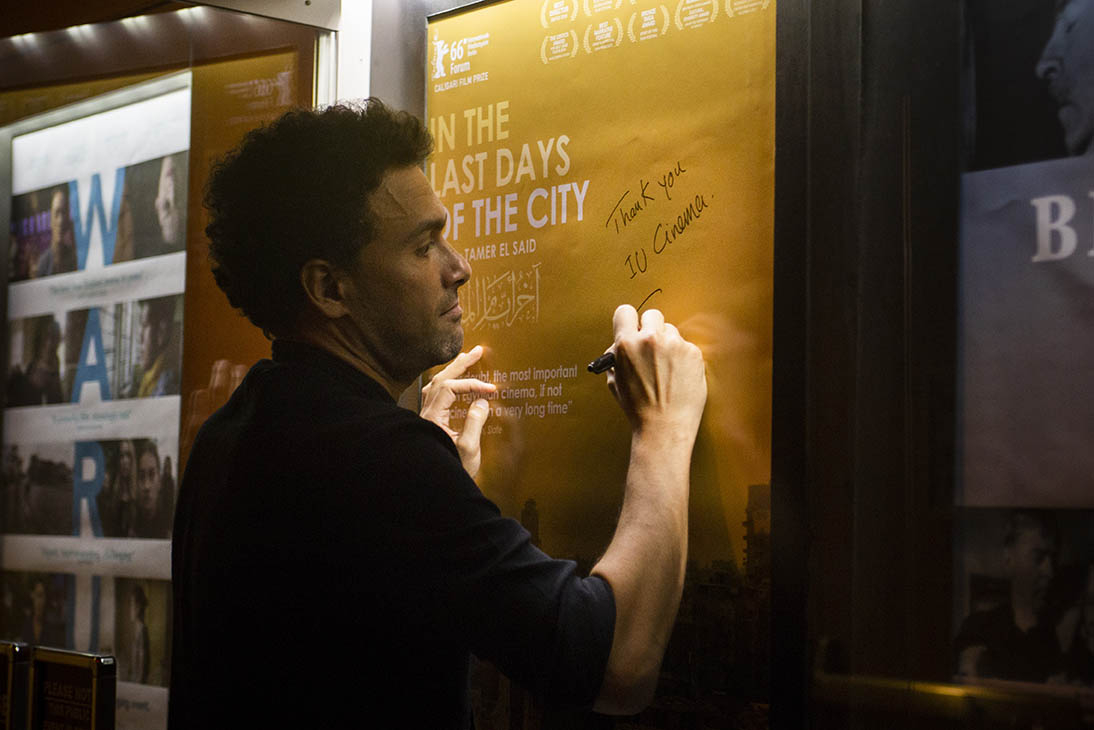 Tamer El Said signs the poster for his film In the Last Days of the City.