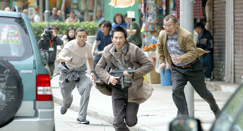 a man with a gun is being chased by two other men with guns from the film Dai Si Gin (Breaking News)