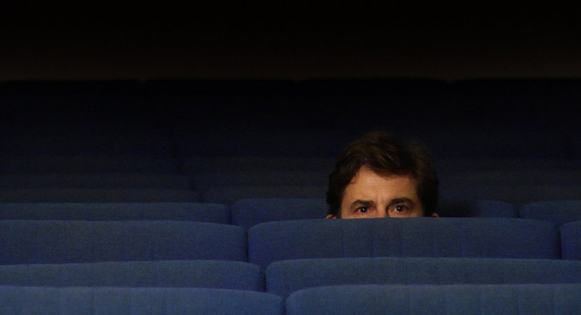 a man sits in a theater from the film To Each His Own Cinema