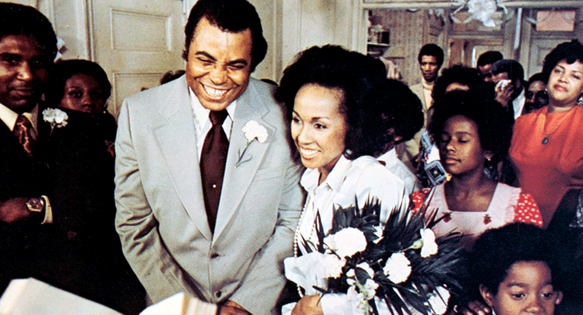 a black couple smile while in a crowd of people from the film Claudine
