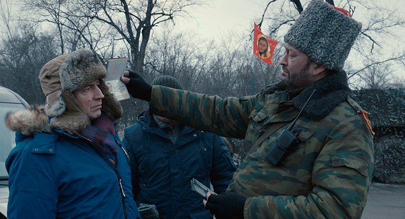 a man checks another mans ID from the film Donbass