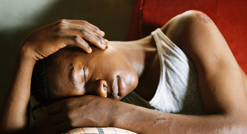 a women rests her head from the film Félicité.
