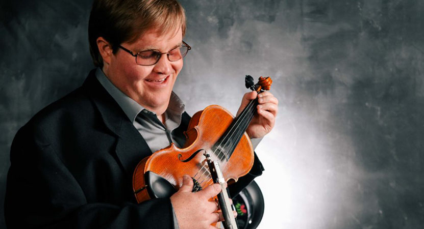 a man holds a violin from the film Flamekeeper: The Michael Cleveland Story