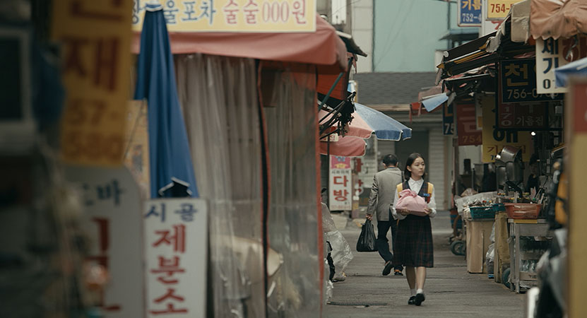 a young women walks down the street from the film 벌새 (House of Hummingbird)