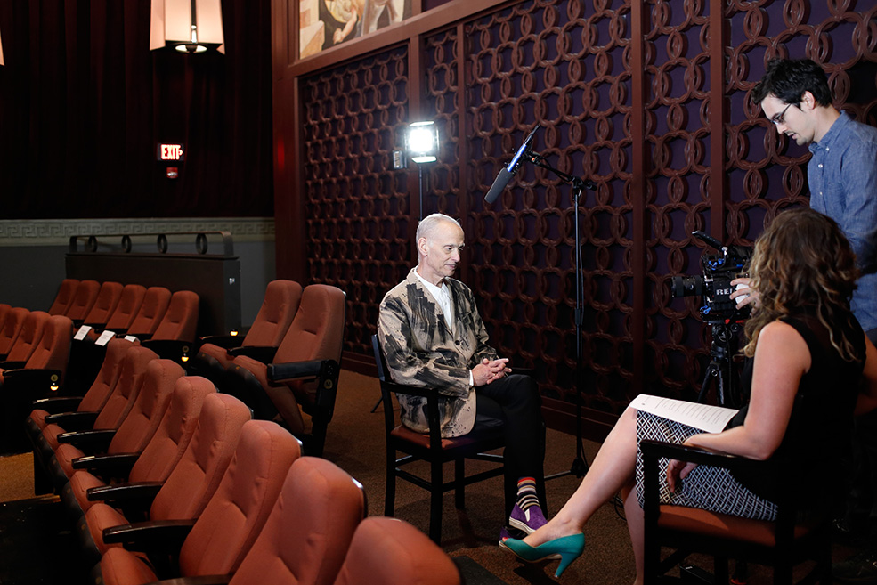 John Waters being interviewed for an IU Cinema Exclusive interview with Associate Director Brittany D. Friesner and Joe Toth.