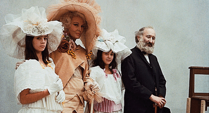 Three women in fancy hats and a man stand together from the film Juliet of the Spirits.