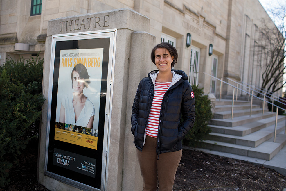 Kris Rey poses by the poster for her series outside of IU Cinema.