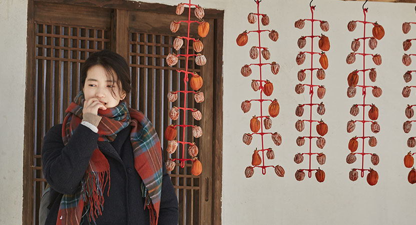 a young women stands outside from the film 리틀 포레스트 (Little Forest)