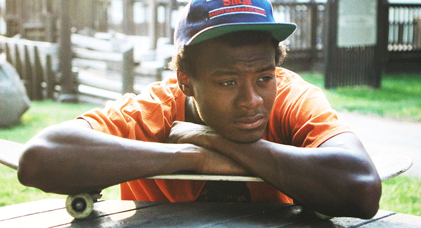 a young man leans on a skateboard from the film Minding the Gap