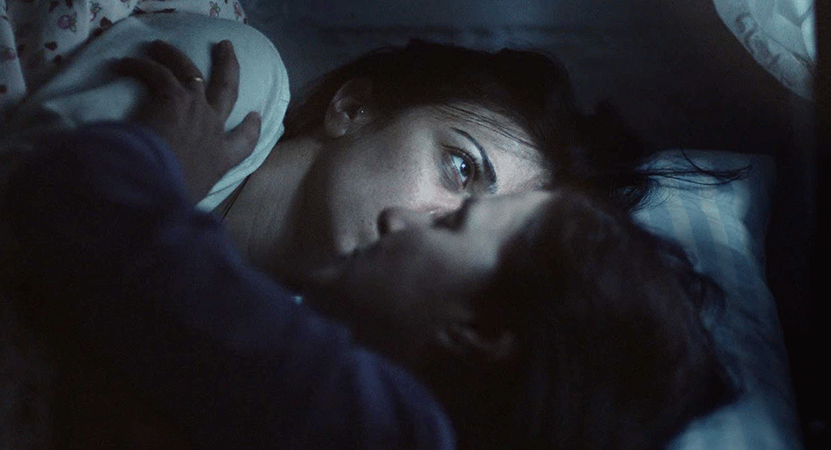 two people lay in bed in the dark from the film Ana Yurdu (Motherland)