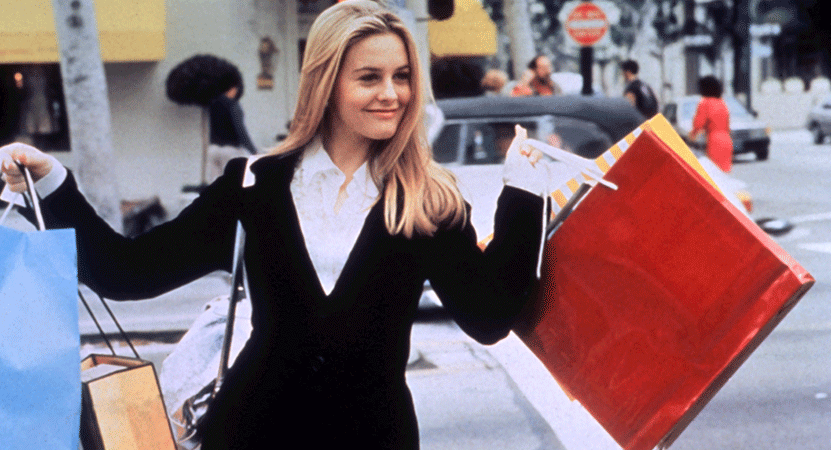 Cher (Alicia Silverstone) holds shopping bags from the film Clueless