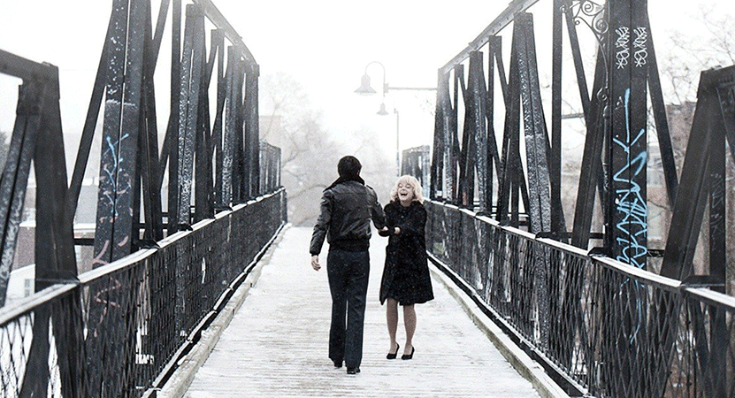 a couple walks across a bridge from the film Stories We Tell