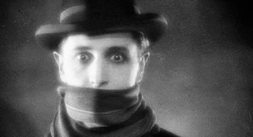 a man looks forward with a  scarf over his mouth from the film The Lodger: A Story of the London Fog