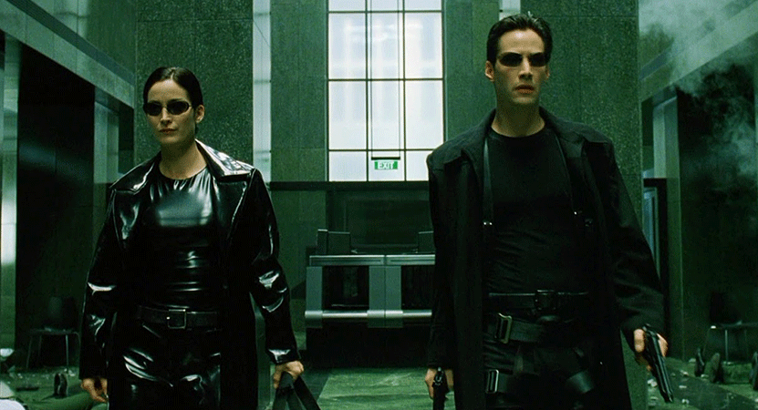 man and women walk through a lobby from the film The Matrix.