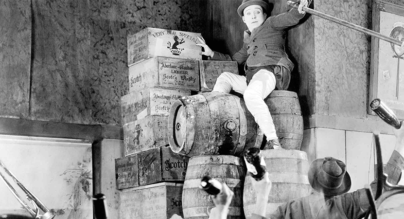 man trying to escape a crowed by climbing onto some barrels from the film The Strong Man.